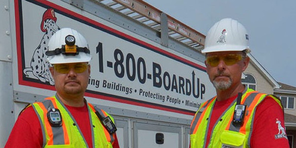 Two Men in Front of the Board Up Truck