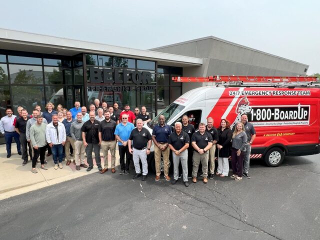 Fast Track graduates, BELFOR CEO Sheldon Yellen, and the 1-800-BOARDUP Home Office team stand together in front of the BELFOR Franchise Group headquarters in Ann Arbor, MI. 